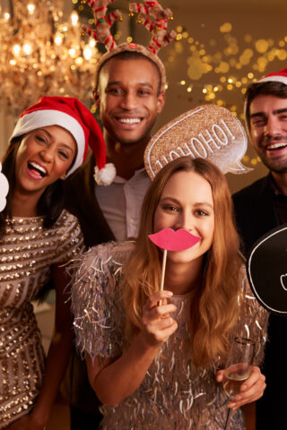 Group Of Friends Dressing Up For Christmas Party Together