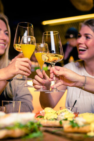 Young women in a bar having fun drinking wine